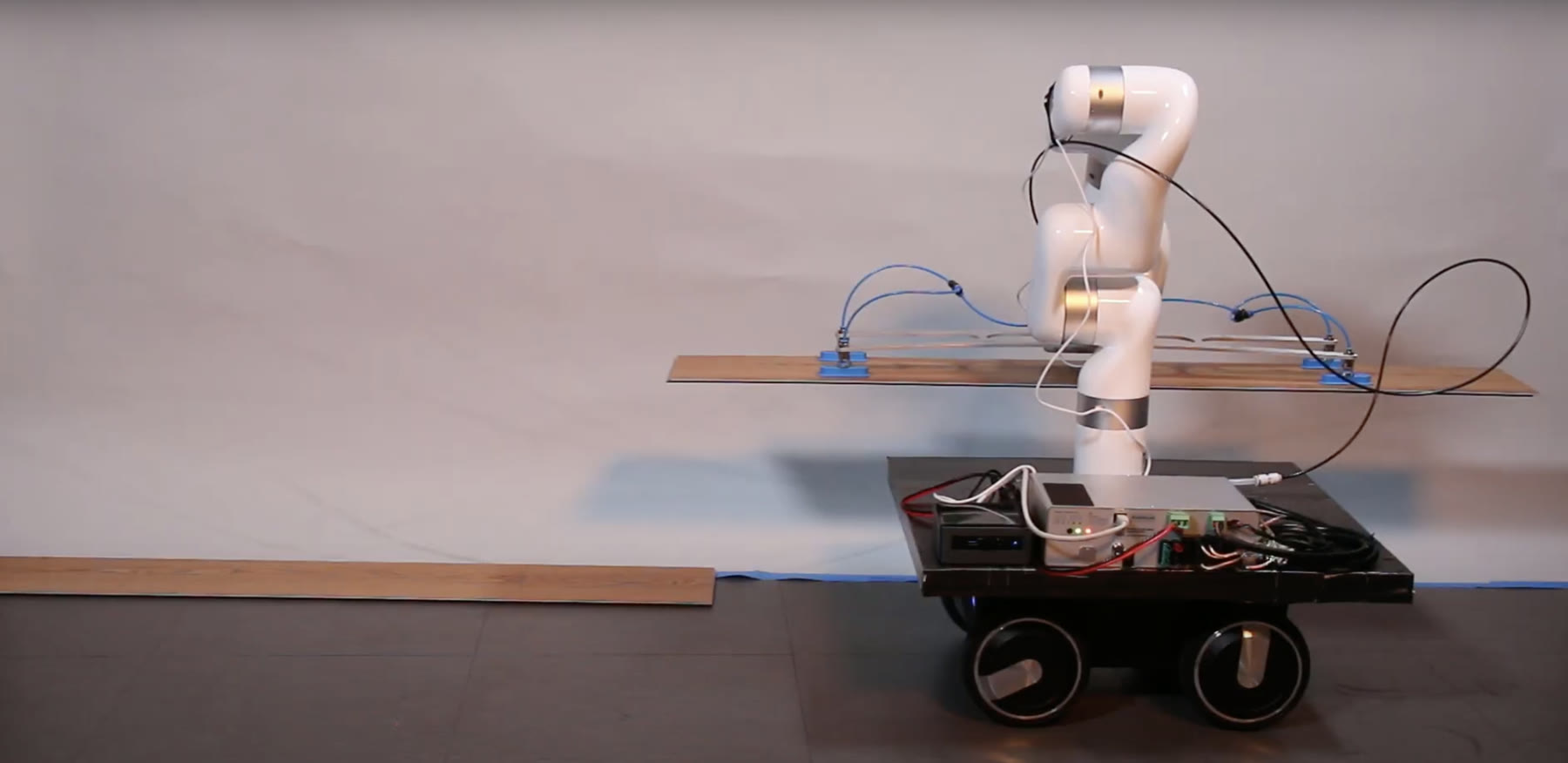 RoBuild robot carrying a flooring plank in the lab